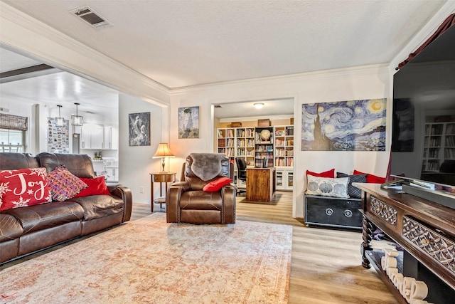 living room with ornamental molding, a textured ceiling, and light hardwood / wood-style flooring