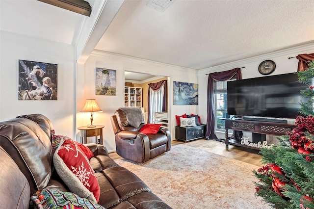 living room with beamed ceiling, light hardwood / wood-style floors, crown molding, and a textured ceiling