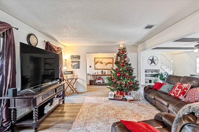 living room with ceiling fan, wood-type flooring, and a textured ceiling