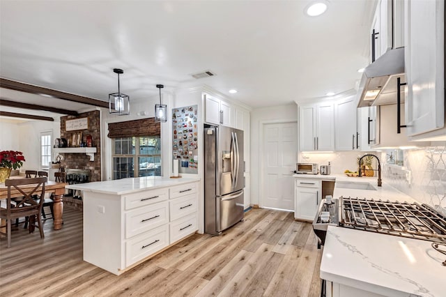 kitchen featuring stainless steel fridge with ice dispenser, light wood-type flooring, decorative light fixtures, and white cabinetry