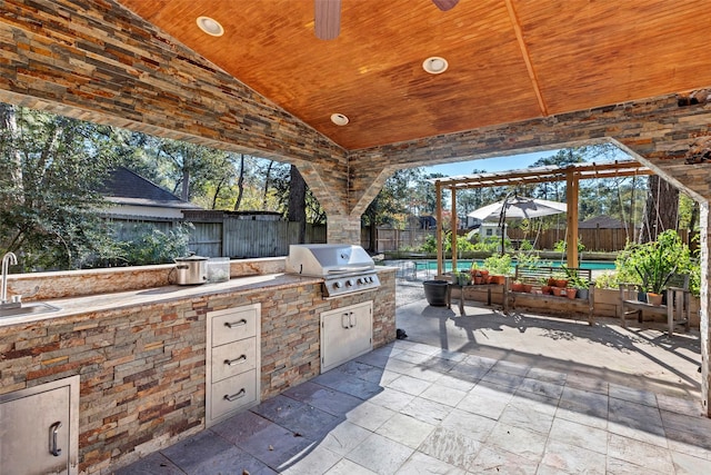 view of patio / terrace featuring ceiling fan, area for grilling, exterior kitchen, and sink