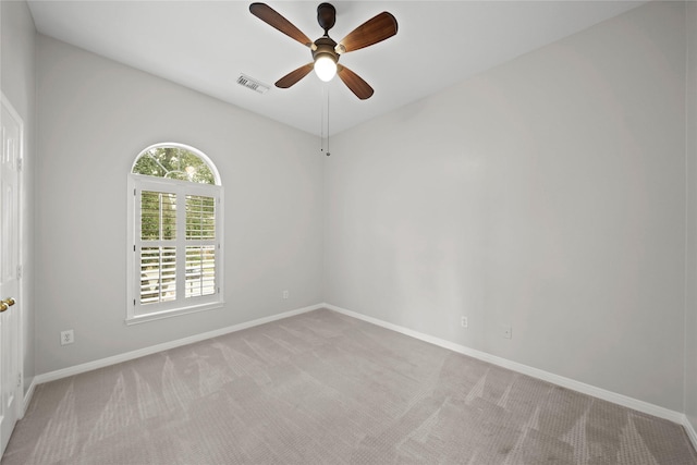 empty room with ceiling fan and light carpet