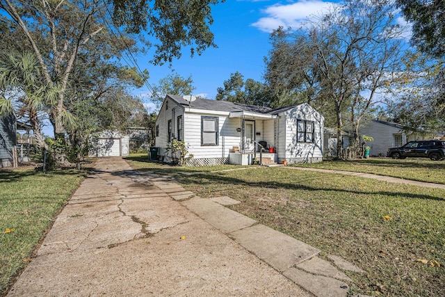 view of front facade featuring a front yard, a garage, and an outdoor structure