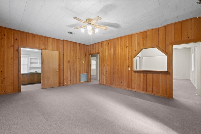 interior space featuring wood walls and ceiling fan