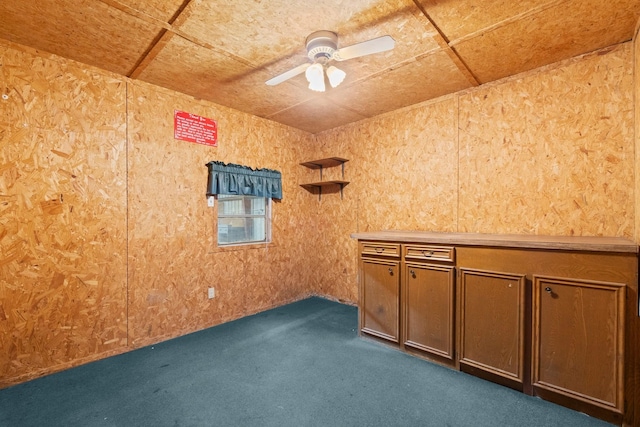 unfurnished room featuring ceiling fan and dark carpet