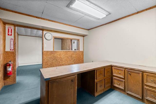 unfurnished office featuring dark colored carpet and ornamental molding