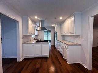 kitchen featuring white cabinets, crown molding, wall chimney exhaust hood, decorative backsplash, and dark hardwood / wood-style flooring