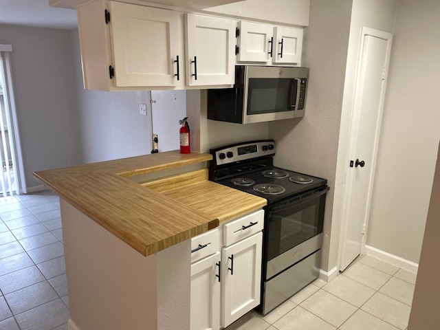 kitchen with white cabinetry, stainless steel appliances, and light tile patterned floors