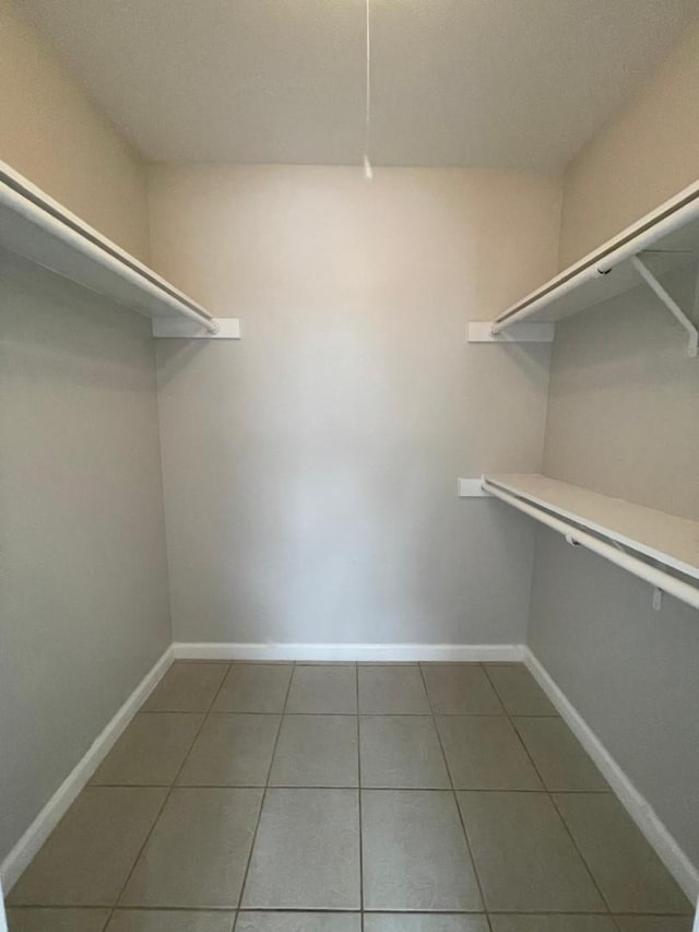 spacious closet with tile patterned flooring and built in desk