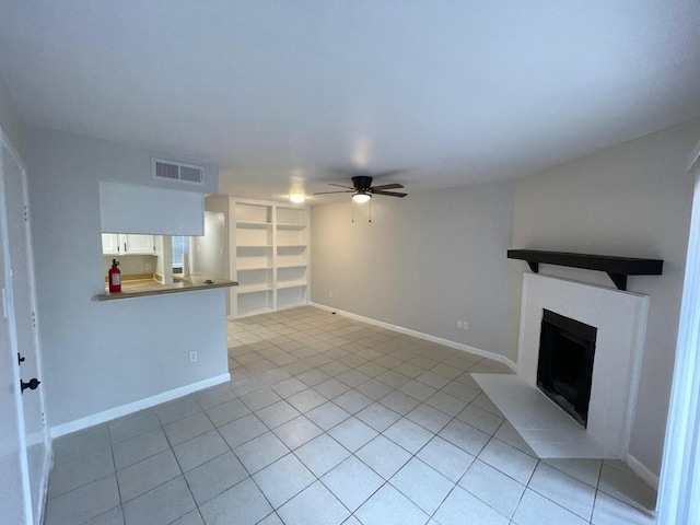 unfurnished living room featuring light tile patterned floors, built in features, and ceiling fan