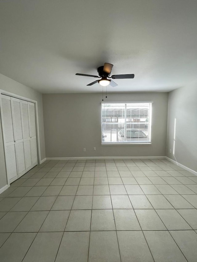 unfurnished bedroom with ceiling fan, a closet, and light tile patterned flooring