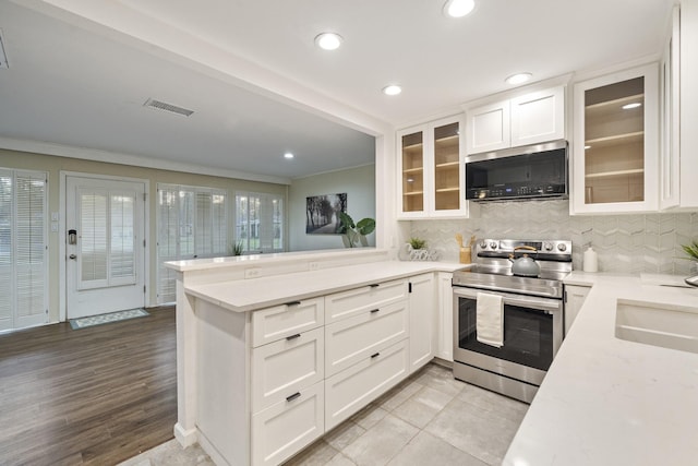 kitchen with light stone countertops, sink, white cabinets, and stainless steel appliances