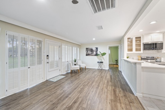 foyer entrance with crown molding and wood-type flooring