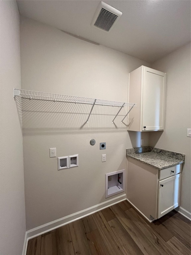 clothes washing area featuring cabinets, hookup for a washing machine, dark wood-type flooring, electric dryer hookup, and hookup for a gas dryer