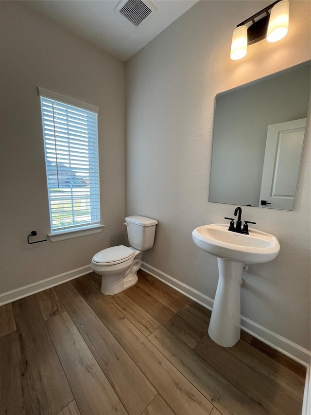 bathroom with hardwood / wood-style flooring and toilet