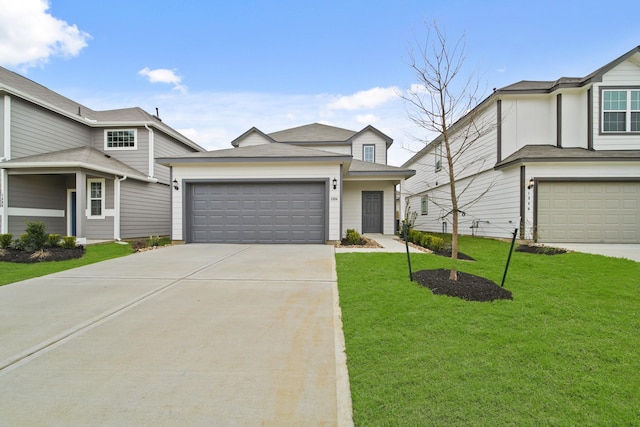 view of front of home with driveway, an attached garage, and a front yard