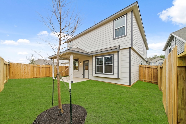 back of house with a lawn, a patio area, and a fenced backyard