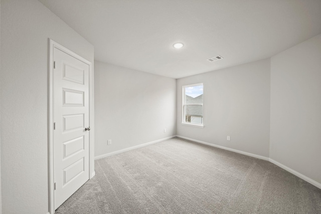 carpeted empty room with visible vents and baseboards