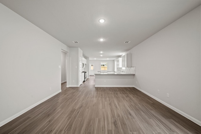 unfurnished living room featuring dark wood-style flooring, recessed lighting, visible vents, and baseboards