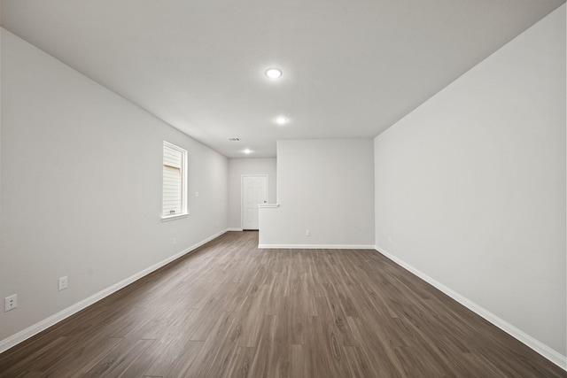 unfurnished room featuring recessed lighting, dark wood finished floors, and baseboards