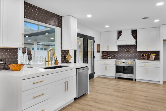 kitchen with appliances with stainless steel finishes, sink, plenty of natural light, and custom exhaust hood