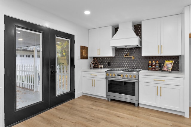 kitchen featuring white cabinets, custom exhaust hood, and high end stainless steel range oven