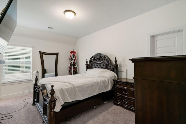 bedroom with visible vents, vaulted ceiling, light carpet, and baseboards