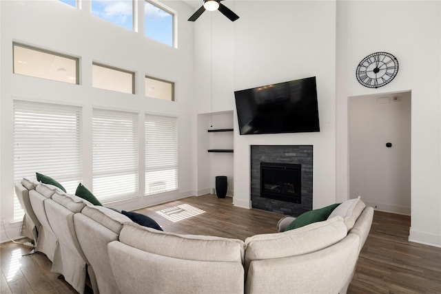 living room with ceiling fan, dark hardwood / wood-style floors, and a high ceiling