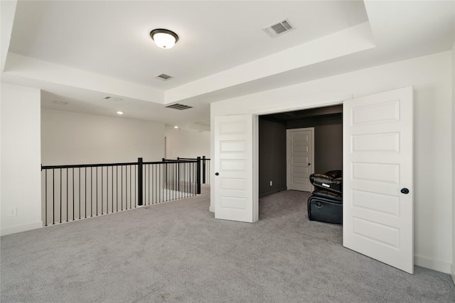 spare room featuring light colored carpet, visible vents, and a tray ceiling