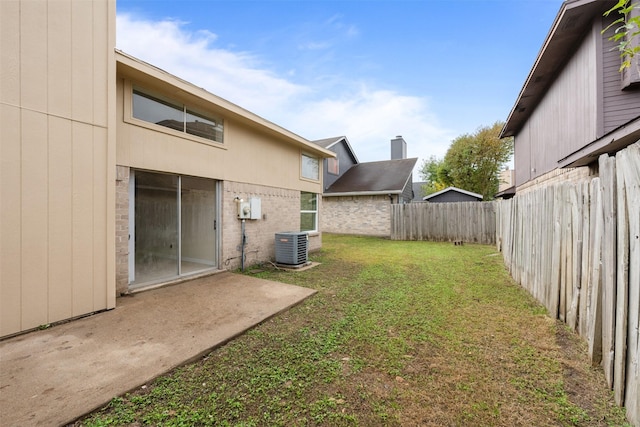 view of yard with central AC and a patio