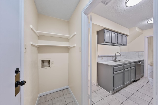 12406 S Rylander Cir, Houston, TX 77071 - clothes washing area featuring washer hookup, light tile patterned flooring, a textured ceiling, and baseboards