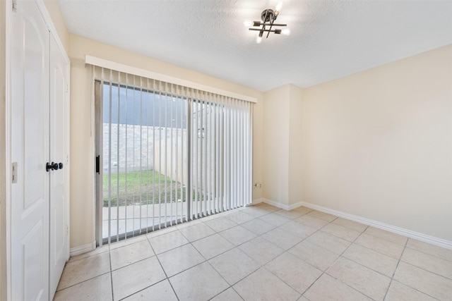 12406 S Rylander Cir, Houston, TX 77071 - spare room with baseboards, tile patterned flooring, a textured ceiling, and a chandelier