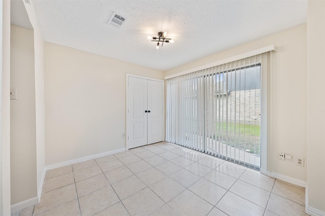 tiled spare room with a textured ceiling