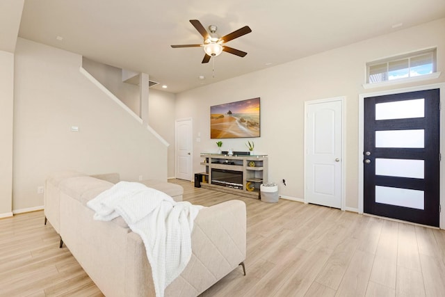 living room with light wood-type flooring and ceiling fan