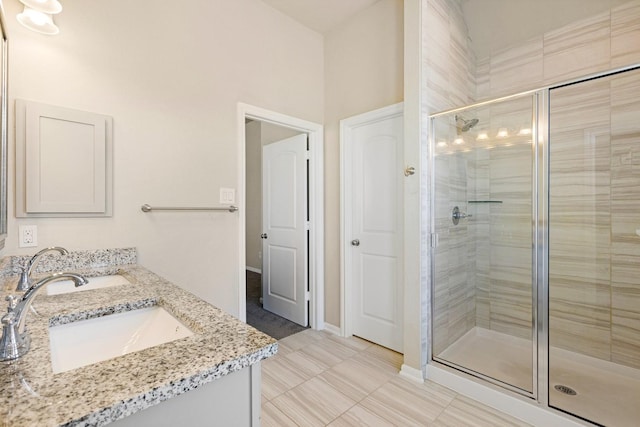 bathroom featuring tile patterned flooring, a shower with door, and vanity