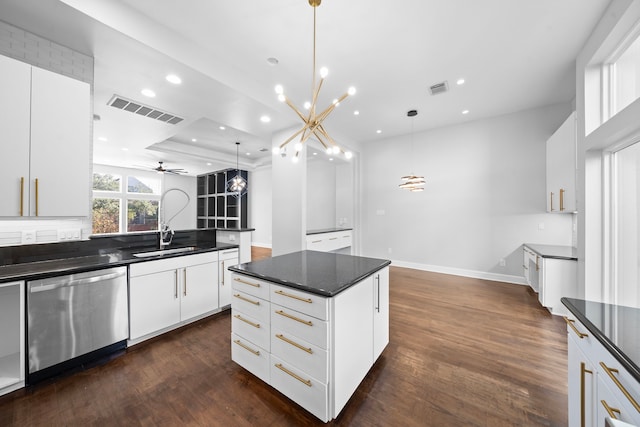 kitchen with dishwasher, white cabinets, ceiling fan with notable chandelier, hanging light fixtures, and dark hardwood / wood-style flooring