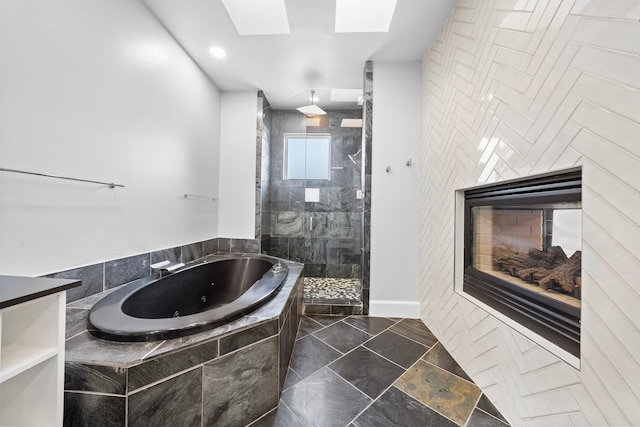 bathroom with a multi sided fireplace, shower with separate bathtub, and a skylight