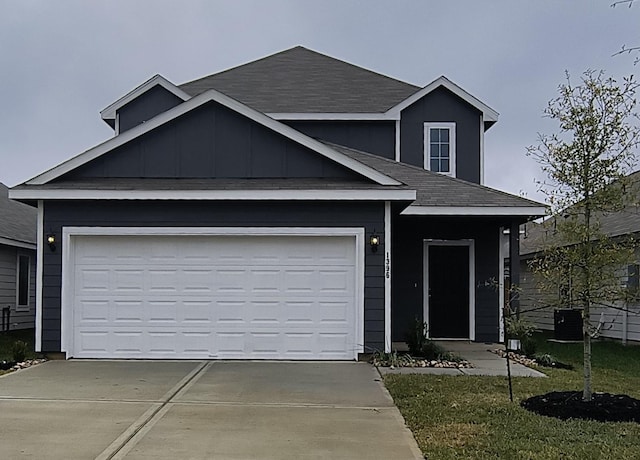 view of front of property featuring a garage, a front lawn, and central air condition unit