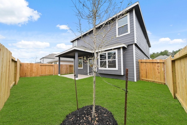 back of property featuring a fenced backyard, a patio, and a yard