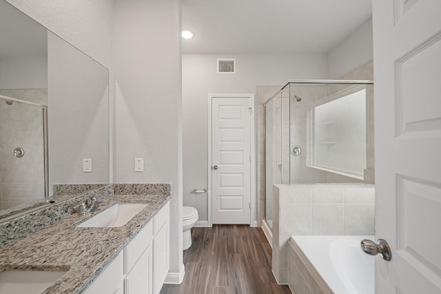 bathroom featuring a garden tub, wood finished floors, a sink, visible vents, and a shower stall