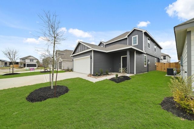 view of front of property with concrete driveway, an attached garage, board and batten siding, a front yard, and fence