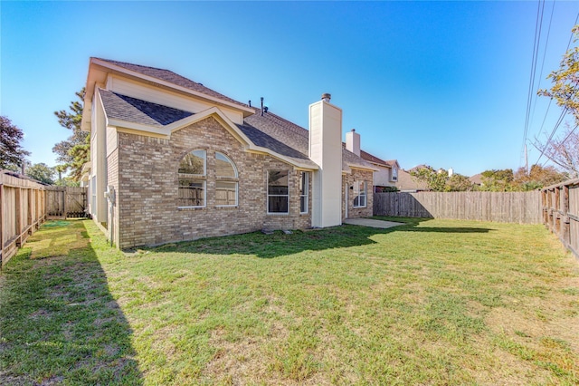 rear view of property featuring a lawn