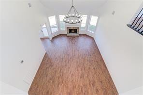 unfurnished living room with a chandelier, dark hardwood / wood-style flooring, and vaulted ceiling