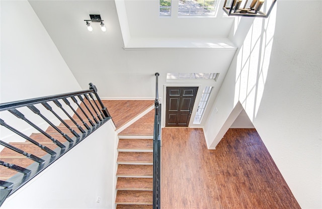 entrance foyer with hardwood / wood-style floors, an inviting chandelier, and a high ceiling