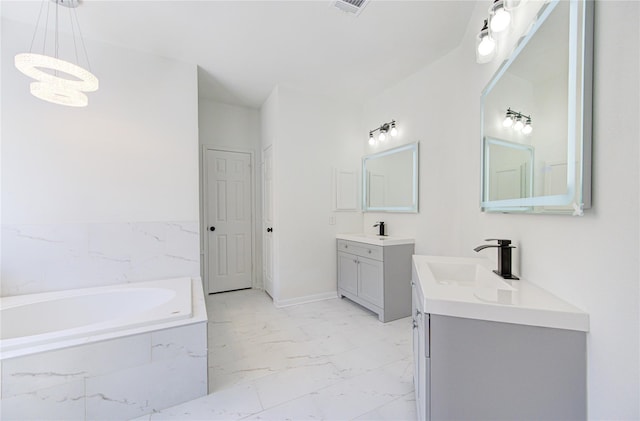 bathroom featuring vanity, a relaxing tiled tub, and an inviting chandelier