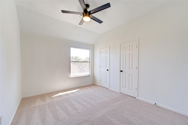 unfurnished bedroom featuring ceiling fan, light colored carpet, and vaulted ceiling