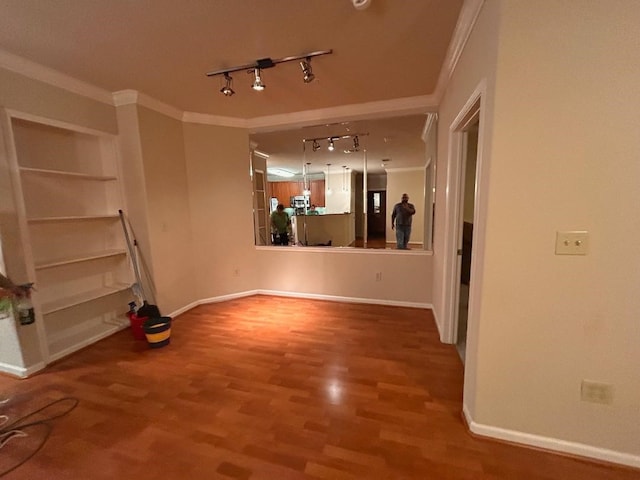 unfurnished living room with crown molding, wood-type flooring, and rail lighting