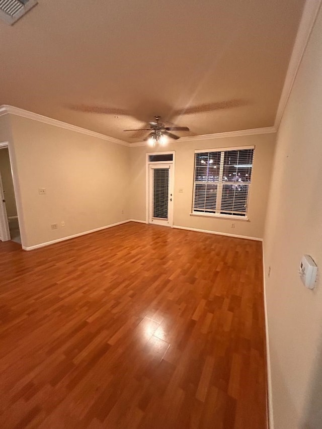 empty room with ceiling fan, wood-type flooring, and ornamental molding