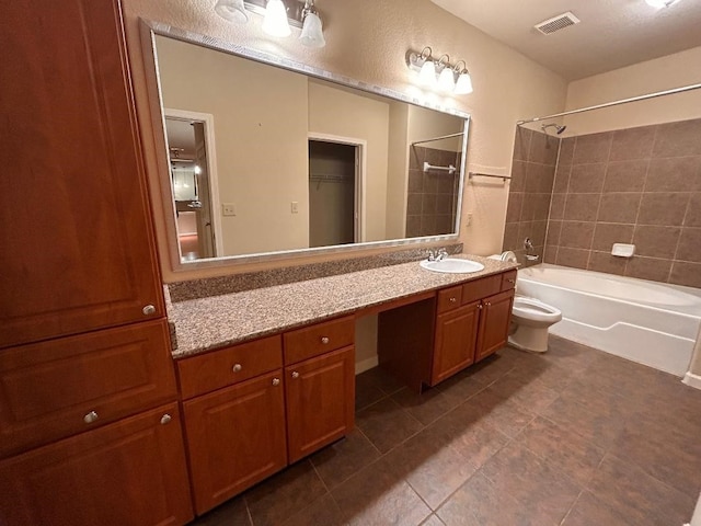 full bathroom with vanity, tile patterned floors, tiled shower / bath combo, and toilet