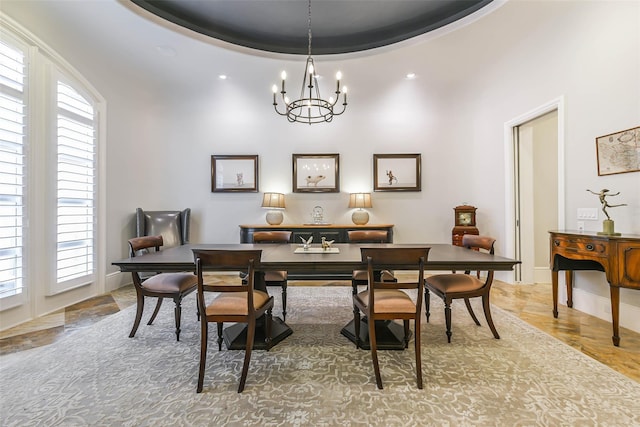 dining room with a notable chandelier, a high ceiling, a wealth of natural light, and a tray ceiling